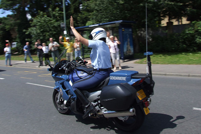 File:Gendarmerie motor officer raising arm in traffic.jpg